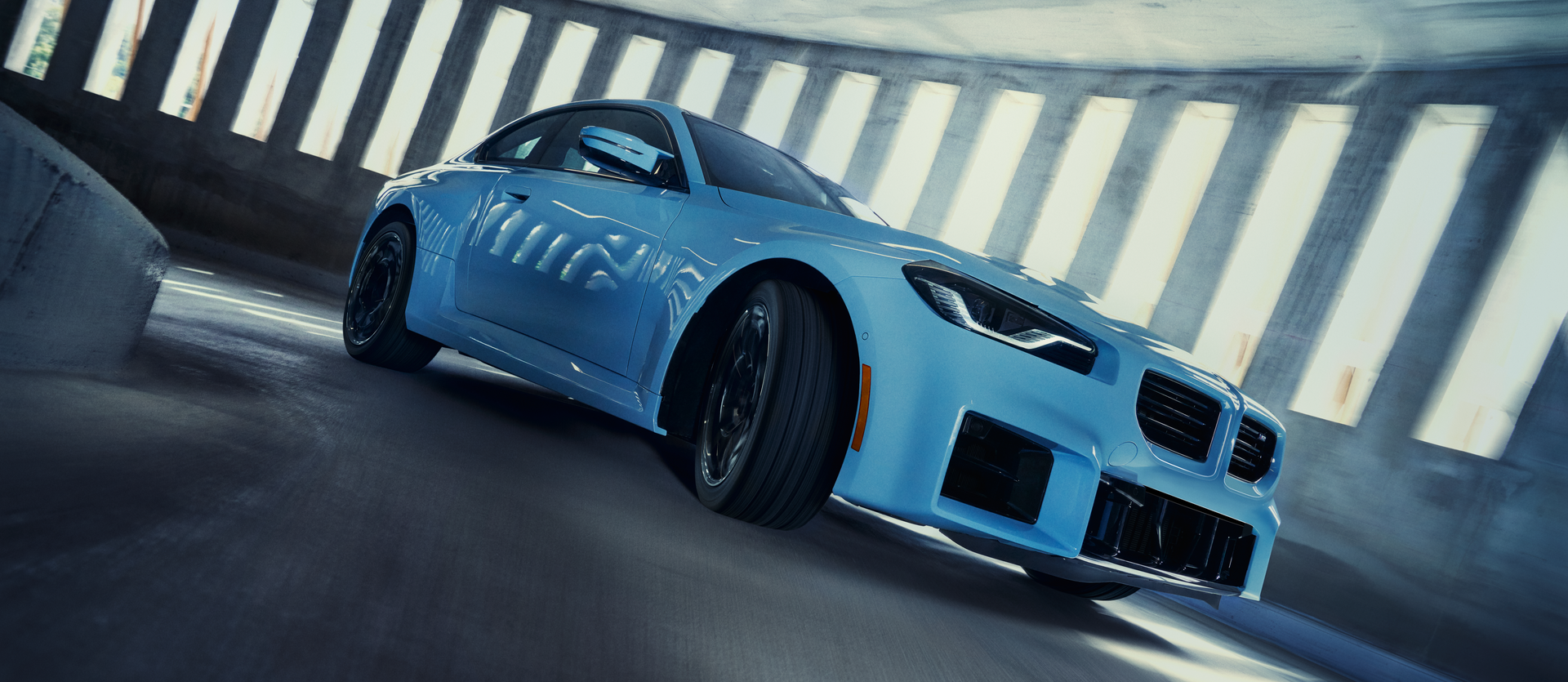 Blue 2-door BMW M2 in a parking garage