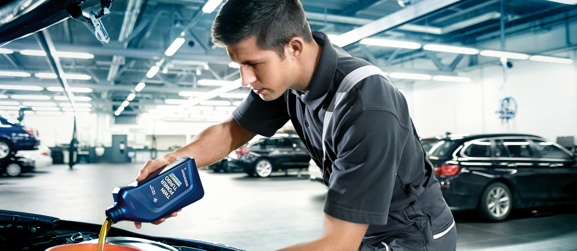BMW service technician performing oil change